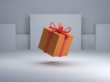 an orange gift box with a red bow