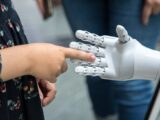 a person holding a robotic hand in front of a mirror
